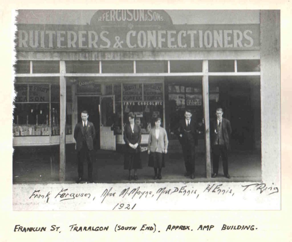 Historic photo of fruit and confectionary store with five staff out the front