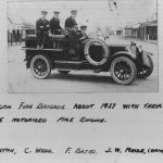Old black and white photo from 1927 of 5 men wearing suits and caps, in a Dodge motorised fire engine
