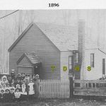 Historic photo of school building with teacher and children infront of the building