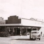 Black and white photo of Jeffereys mens store and car turning corner in main street at Traralgon