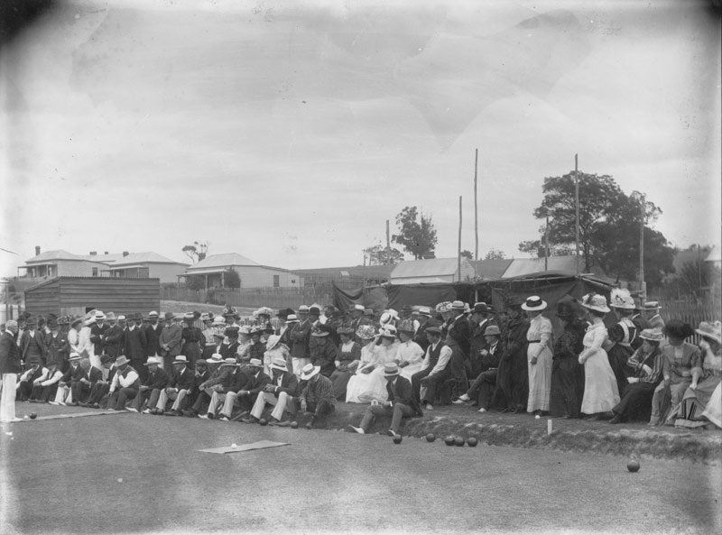 Historic photo of large group of men and women watching bowls